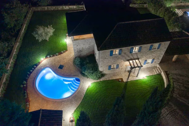 Luxurious beautiful modern villa with swimming pools and yard garden, aerial view by night, Istria, Croatia